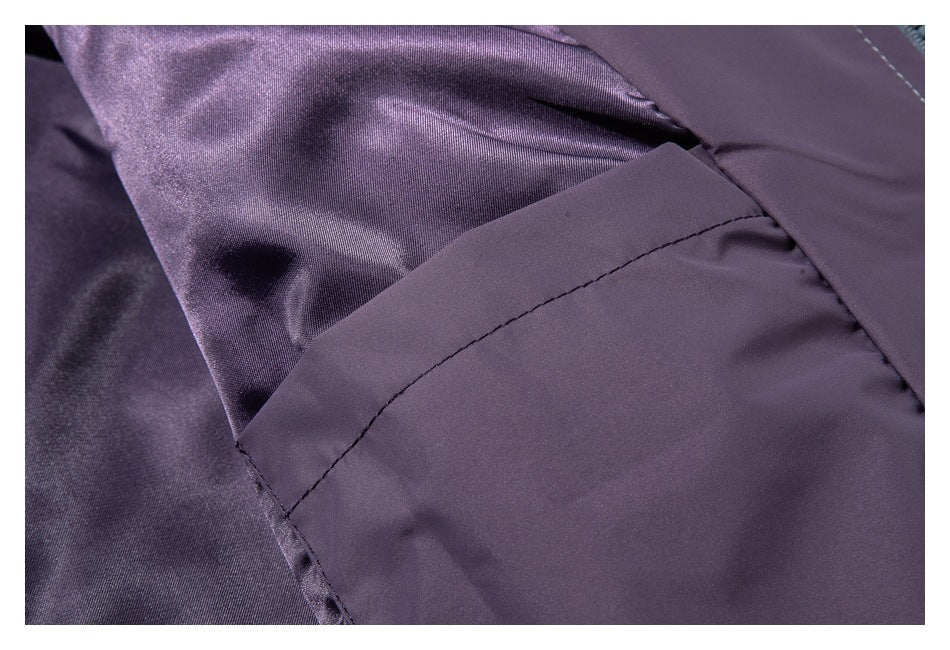 Close-up of purple fabric with a curved stitched seam and overlapping panels.