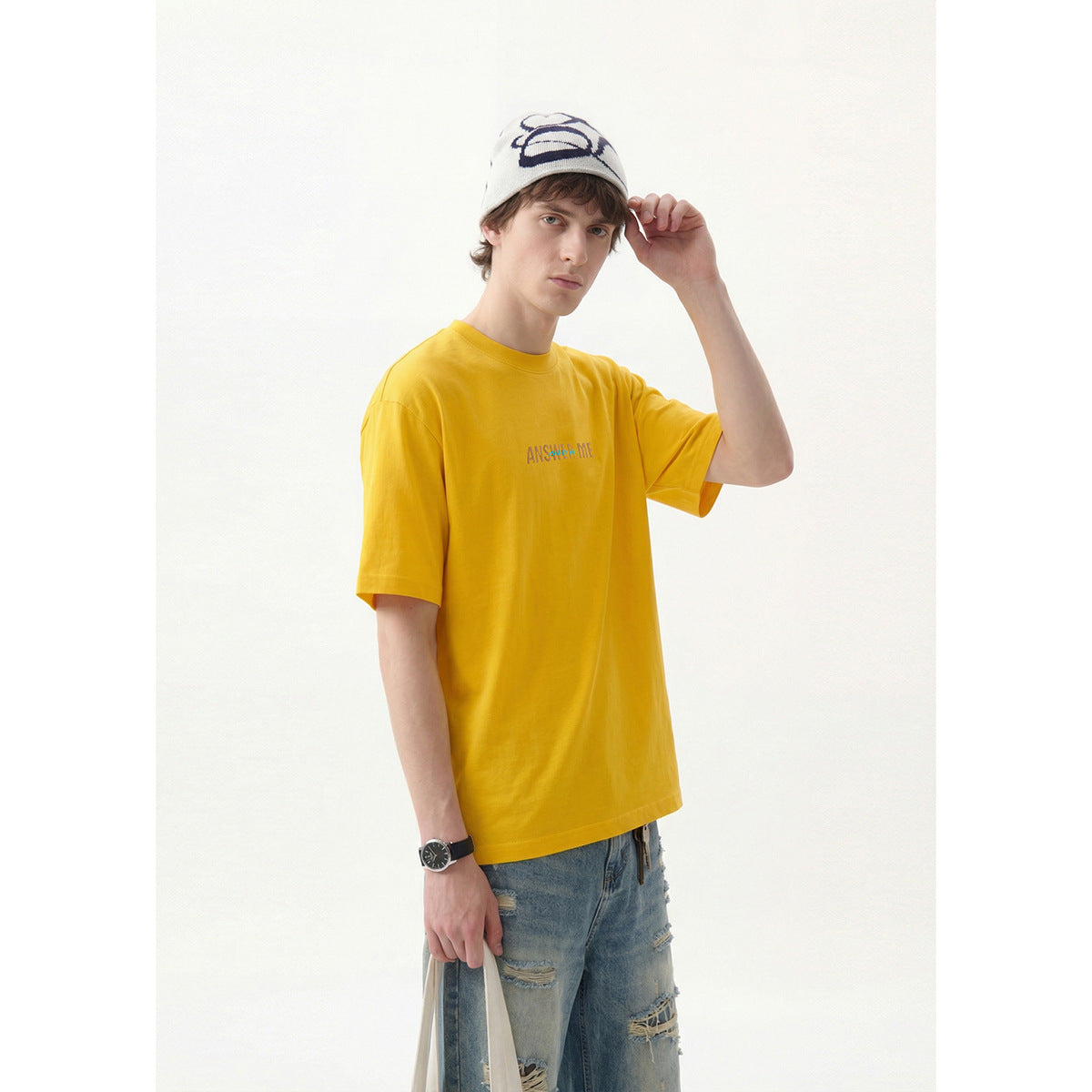 Model wearing a bright yellow short-sleeve T-shirt with small chest lettering, shown from the front.