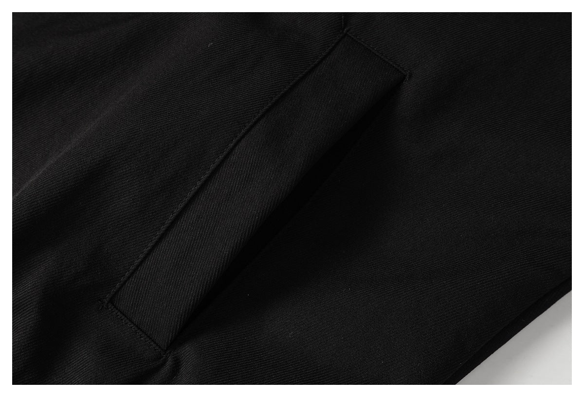 Close-up of a slanted welt pocket on black fabric.