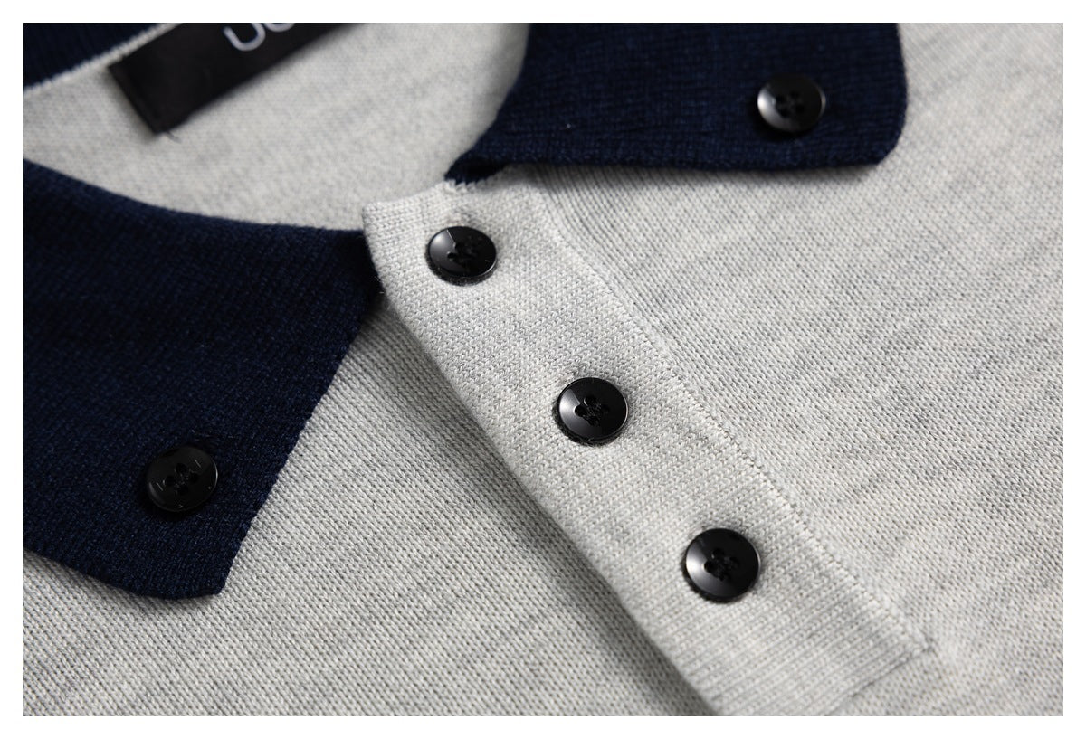 Close-up of the light gray knit polo's navy collar and black buttons along the front placket.