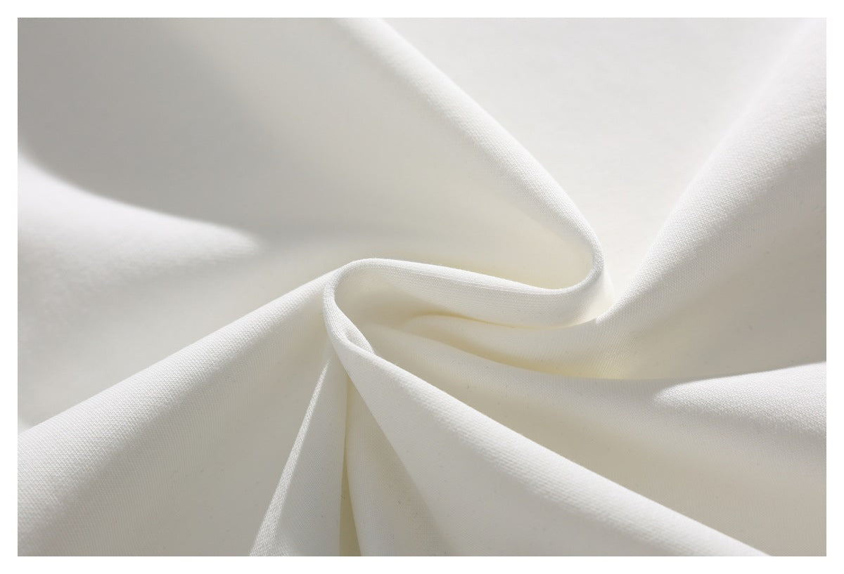 Close-up of plain white fabric arranged in soft folds, showing its fine woven texture.