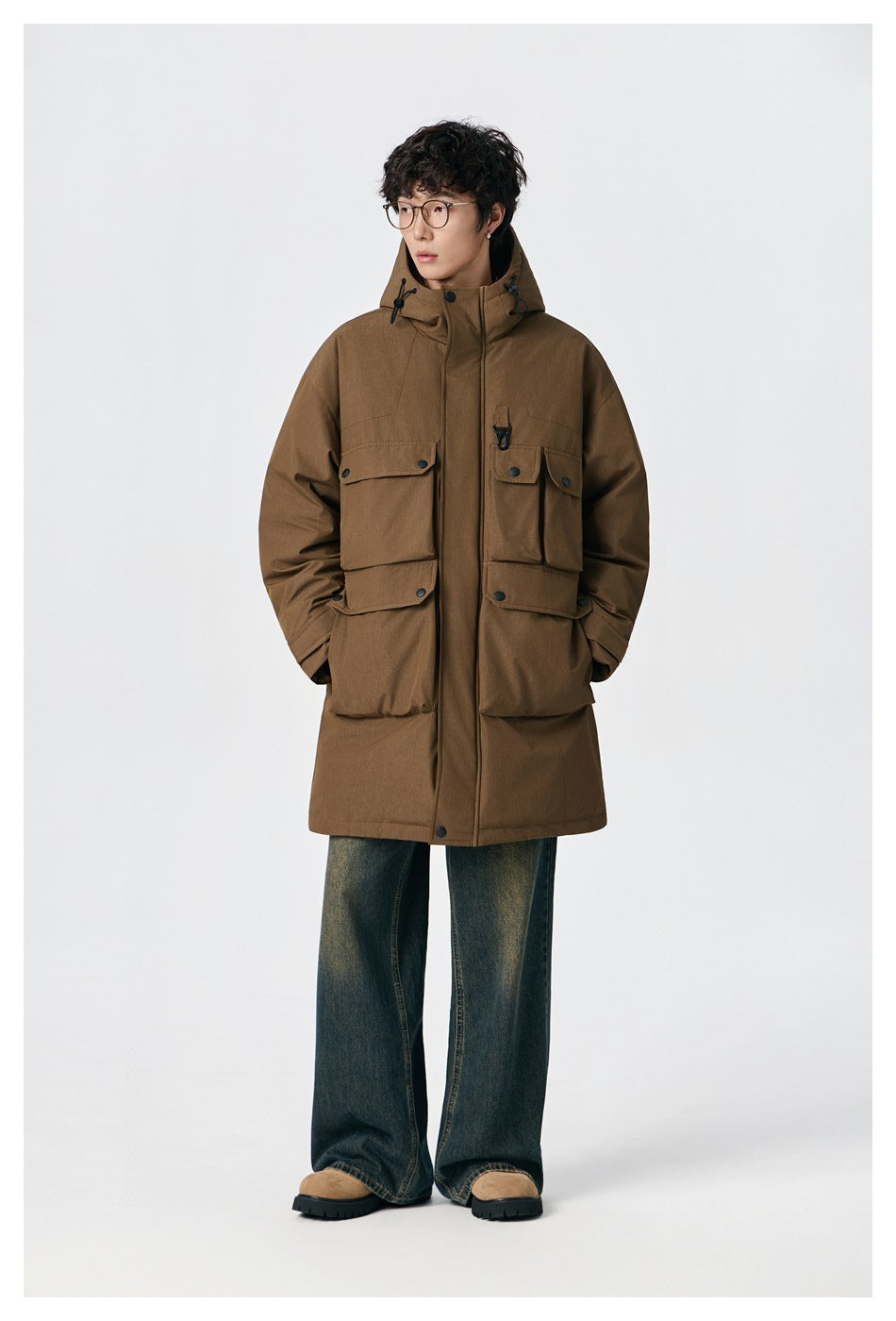 Model wearing brown longline hooded jacket zipped up, front view, with wide-leg jeans and suede boots