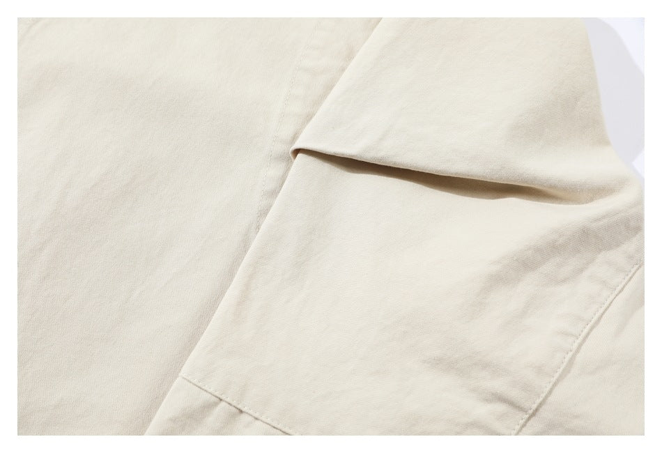 Close-up of overlapping ivory garment panels with visible stitching and a folded edge.