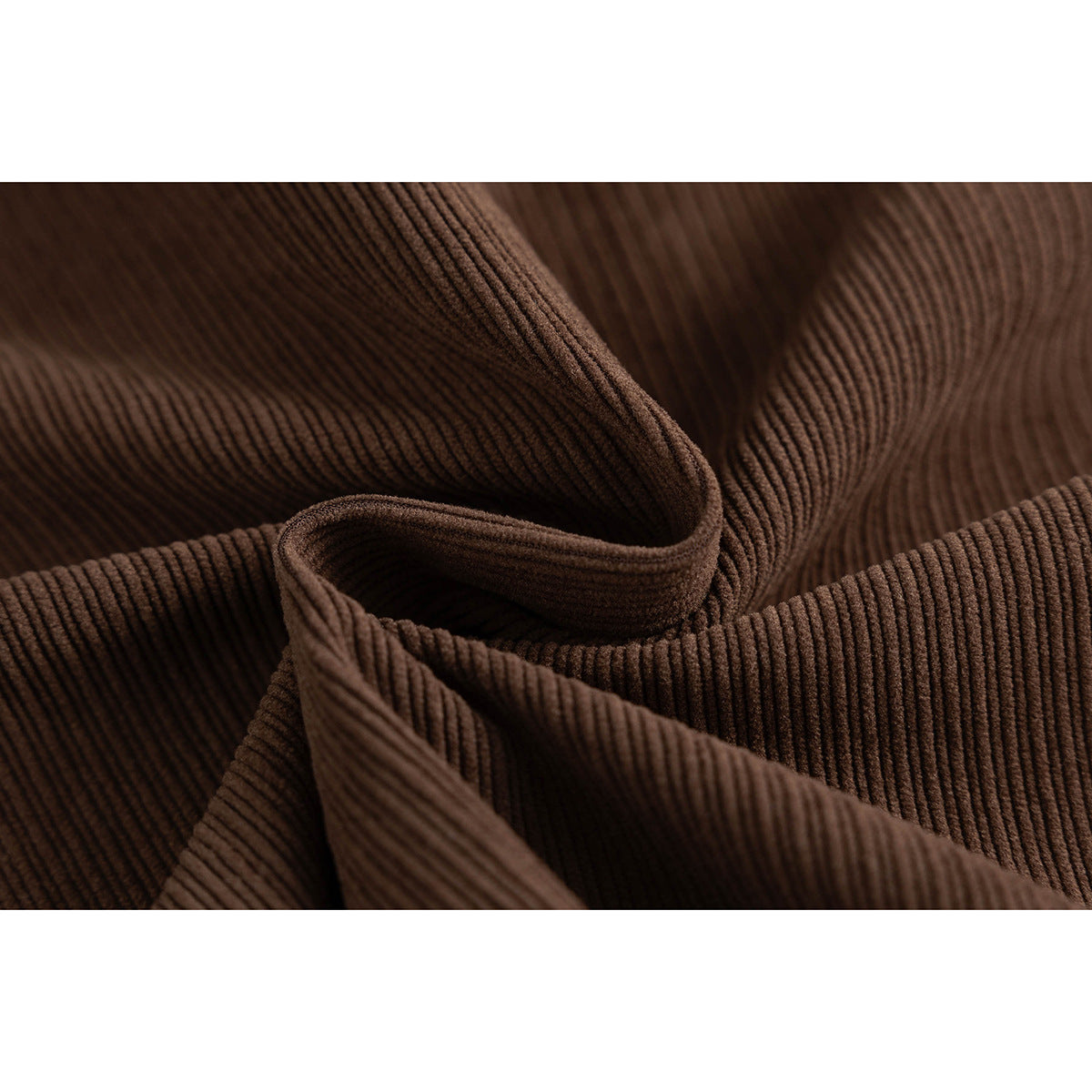 Close-up of the brown jacket's raised, narrow ribbed texture and folded fabric.
