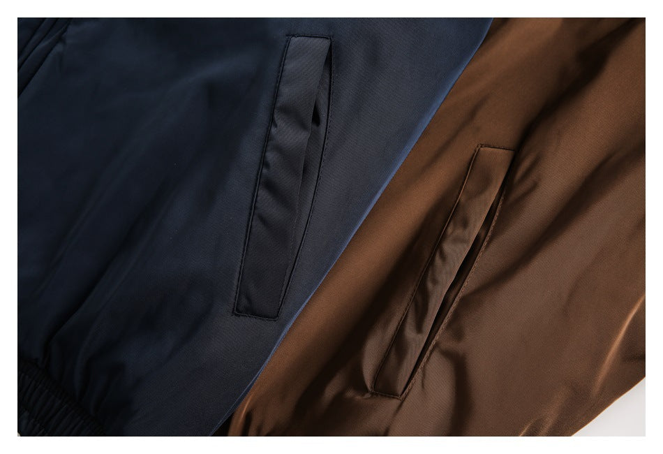 Close-up of diagonal welt pockets on navy and brown jacket fabric.