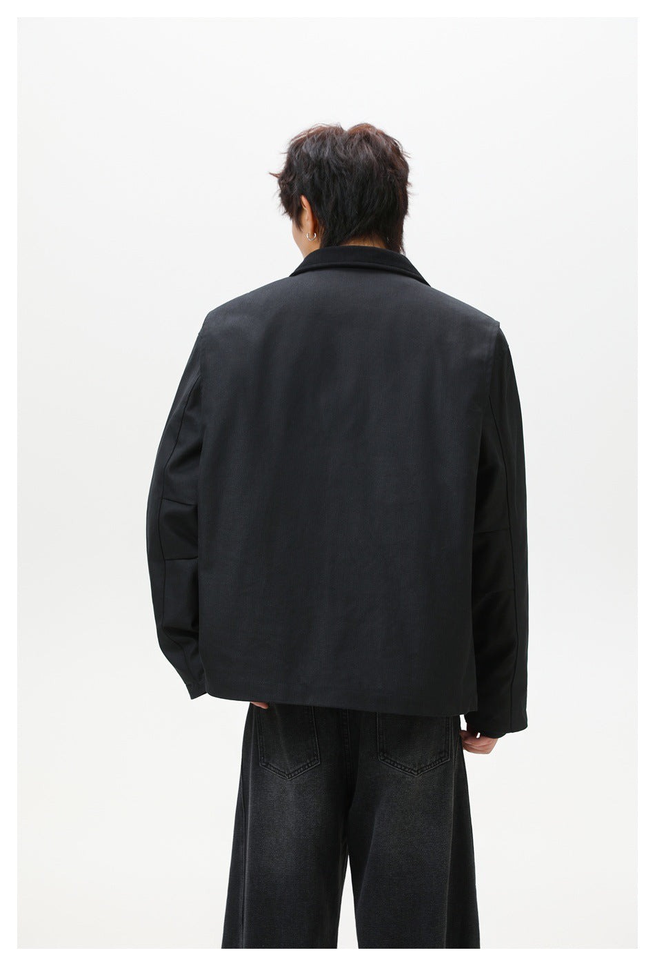 Back view of a model wearing a black collared jacket with wide-leg black jeans