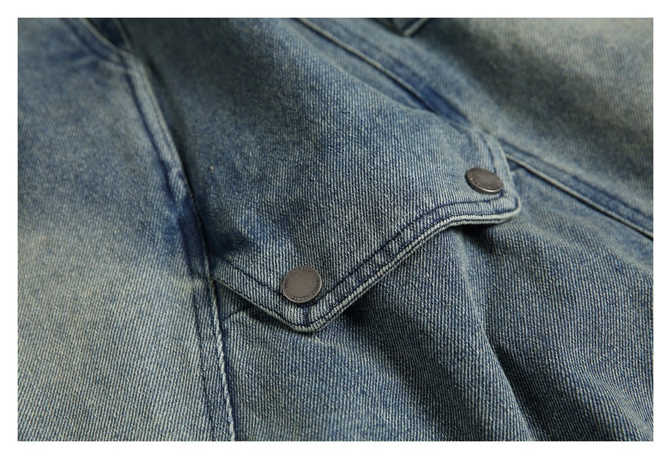 Close-up of a stitched denim flap secured with two dark metal buttons.