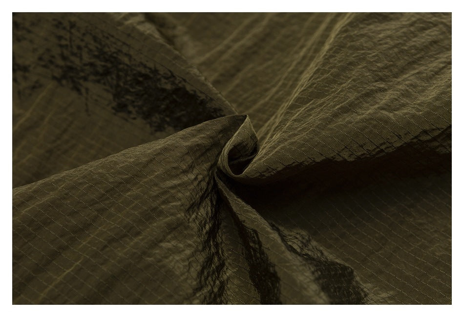 Close-up of olive fabric gathered to show its subtle grid texture and sheen.