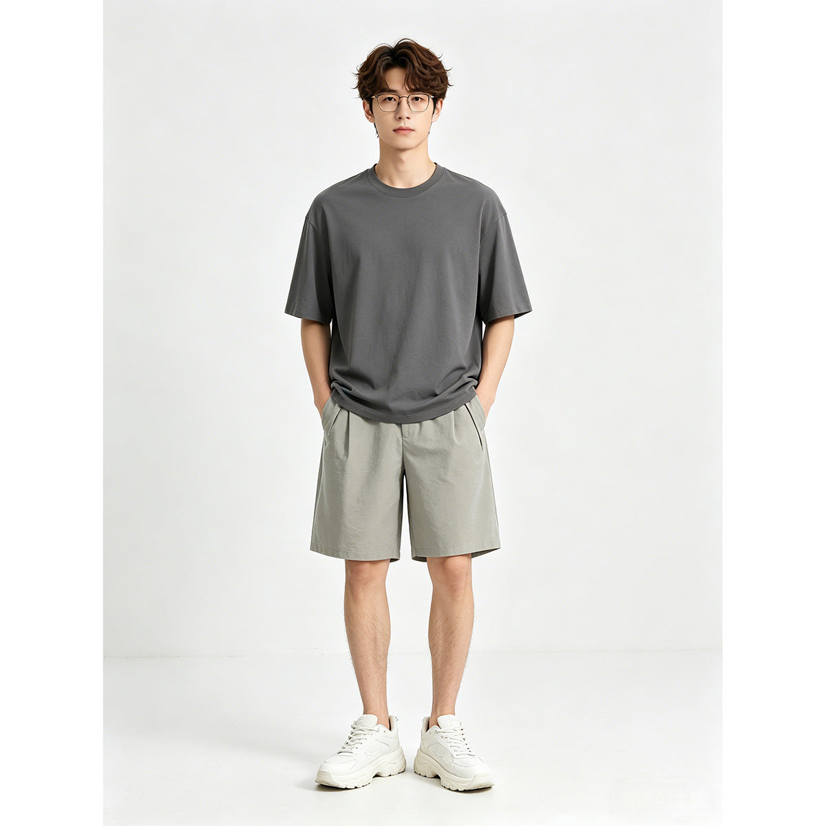 Model wearing a charcoal-gray oversized T-shirt and light gray shorts, front view.