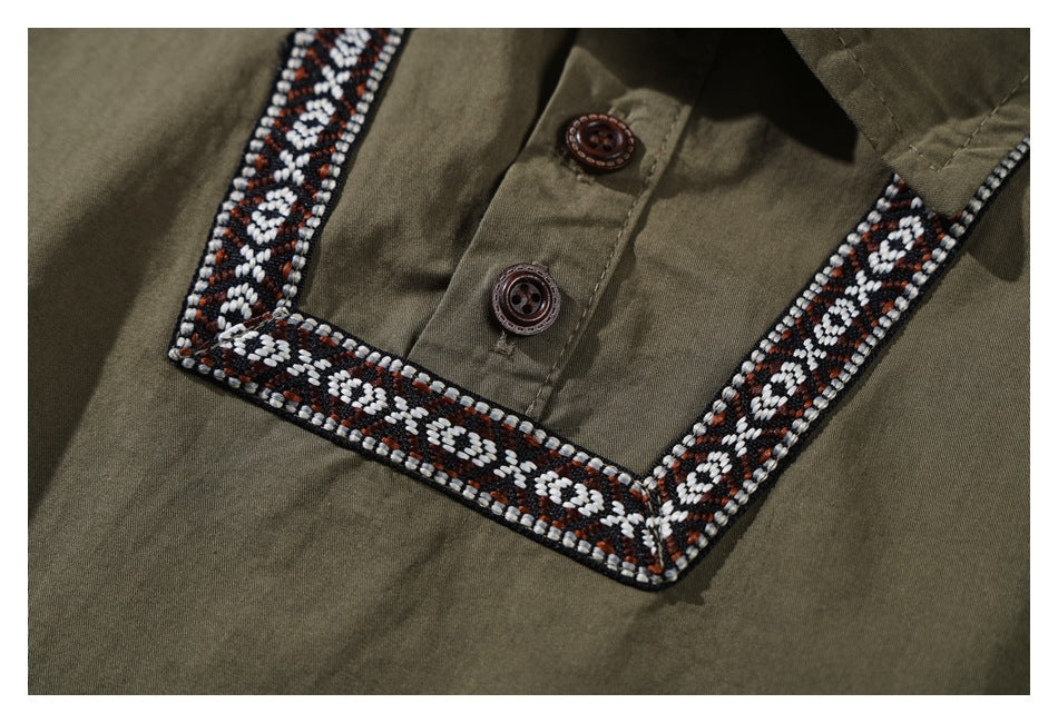 Close-up of an olive shirt's button placket with black, white, and rust geometric trim around the neckline.