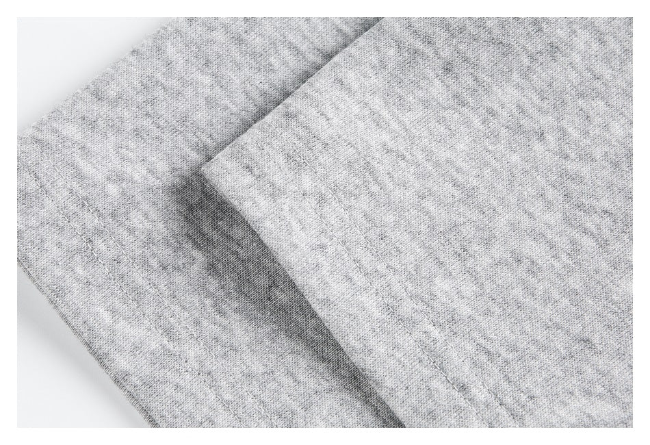 Close-up of light gray heather fabric with overlapping stitched garment panels.