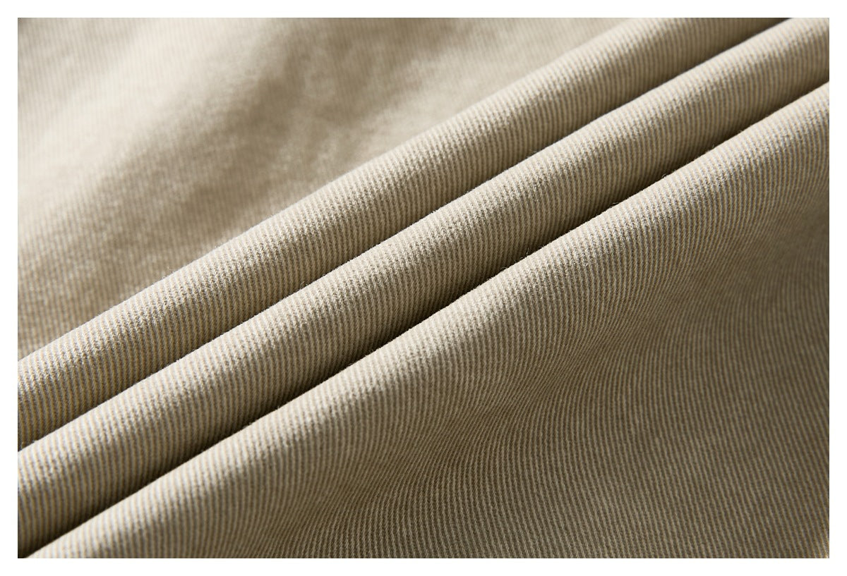 Close-up of beige jacket fabric draped in folds, showing its fine diagonal weave.