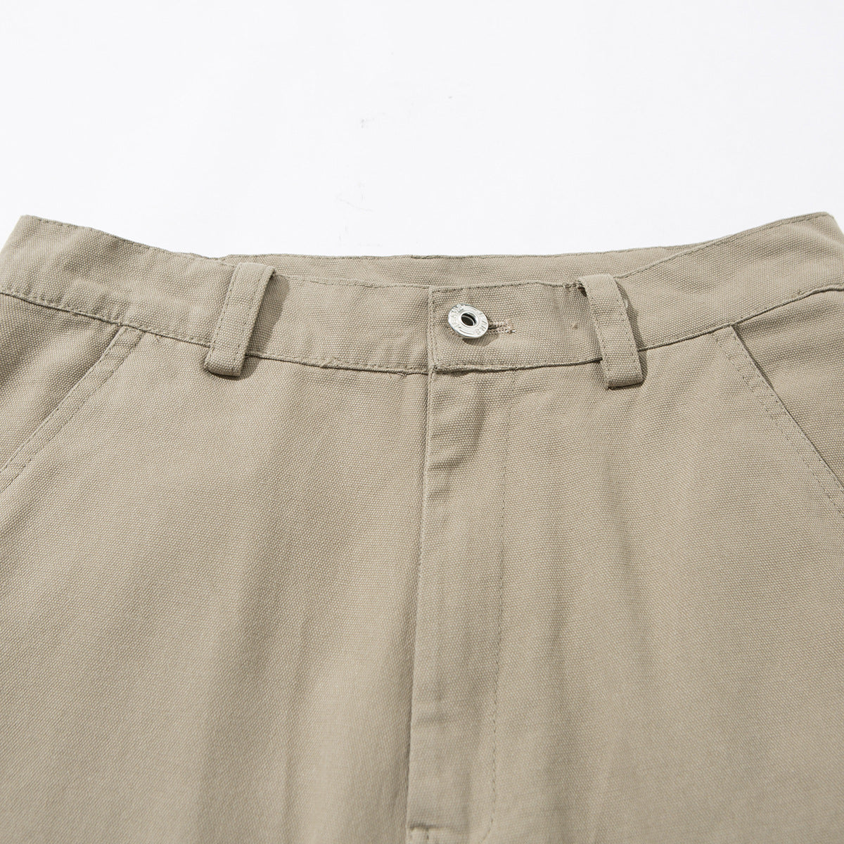 Close-up of beige cargo pants showing the waistband, belt loops, metal button, fly and angled pocket openings.