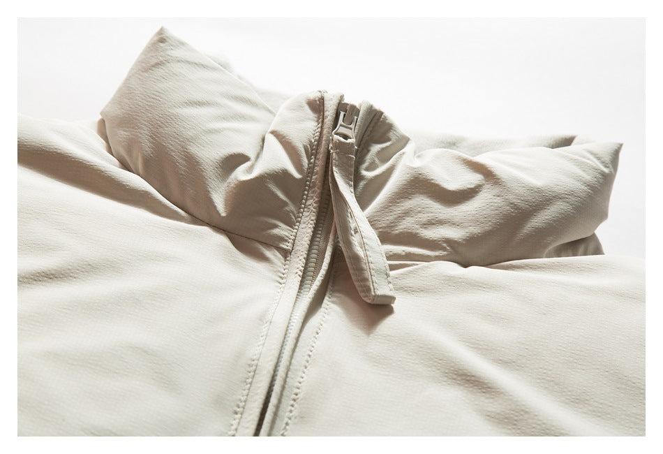 Close-up of an off-white jacket collar and central zipper with a long fabric pull tab.