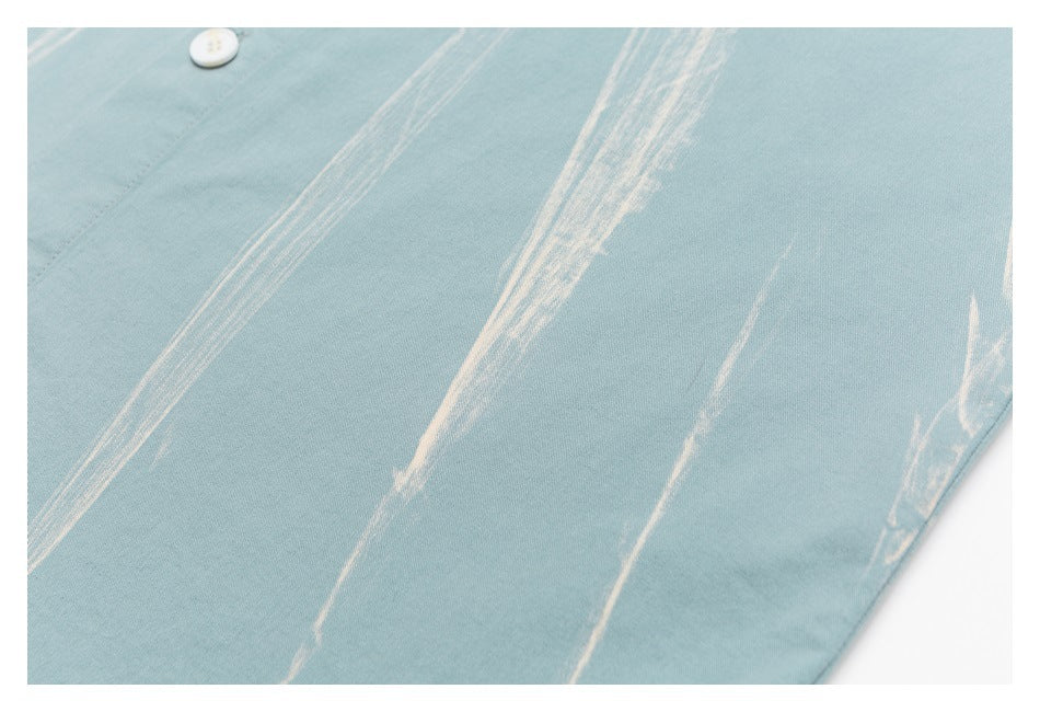 Pale blue shirt fabric with irregular white streaks and a small white button.