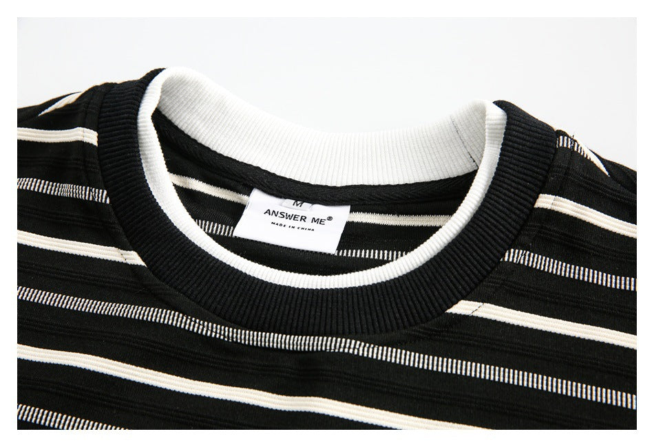 Close-up of a black-and-white striped top's ribbed crew neckline and sewn-in label.