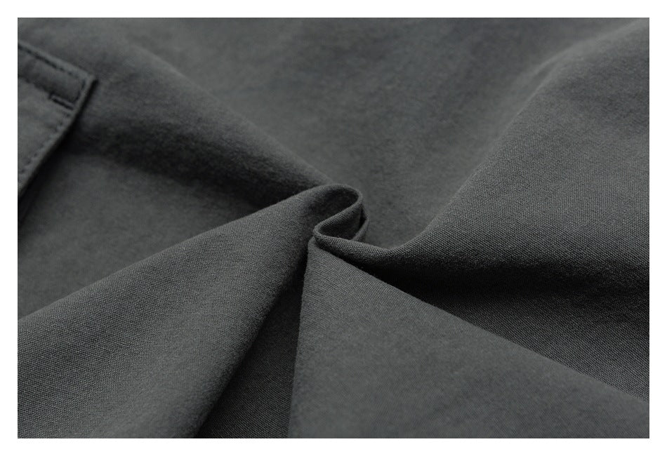 Close-up showing the dark charcoal garment fabric's fine weave and folded seam.