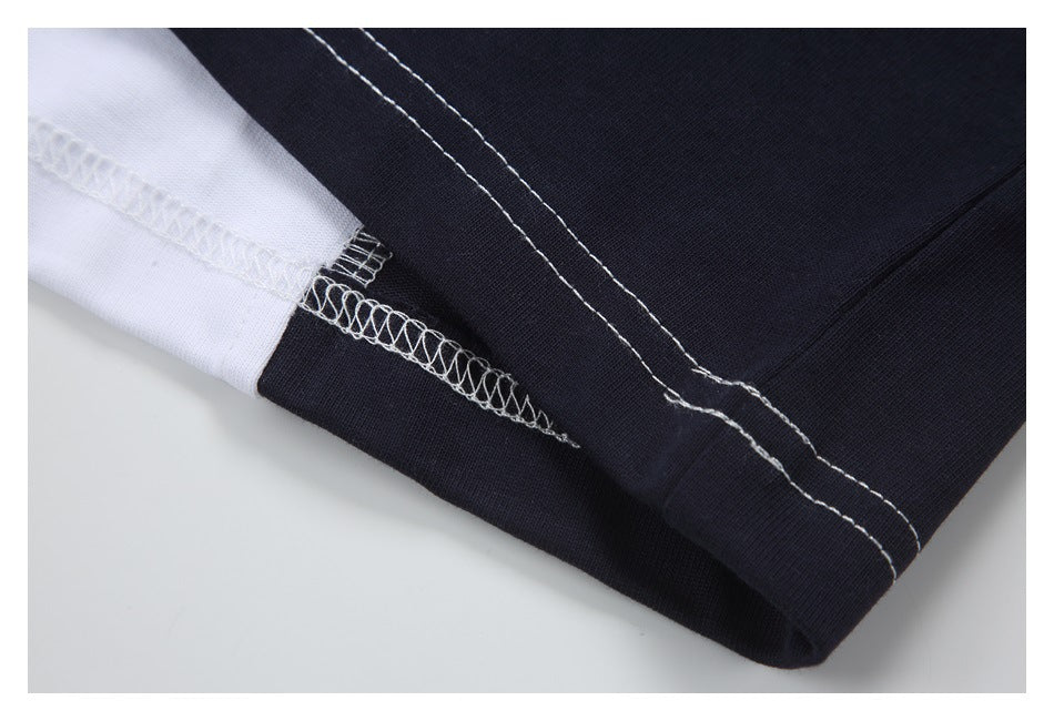 Close-up of a black-and-white garment seam with visible white overlock stitching.