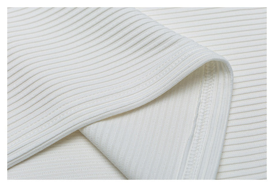 Close-up of white ribbed knit fabric showing a folded edge and overlocked seam.