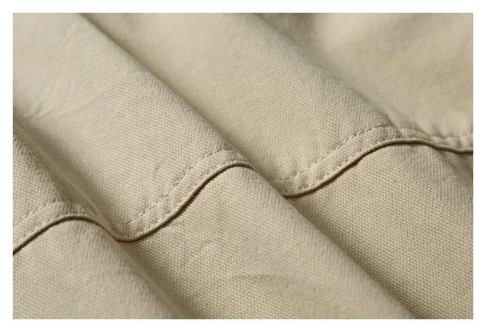 Close-up of beige jacket fabric folds and stitched seam finishing.