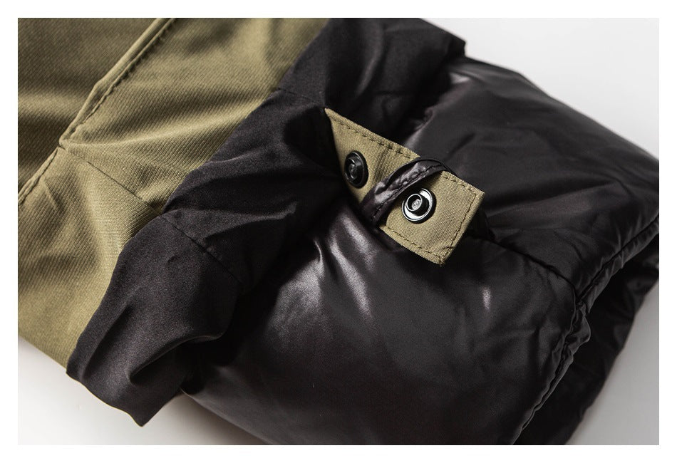 Close-up of a black padded jacket with an olive snap tab and adjacent olive fabric.