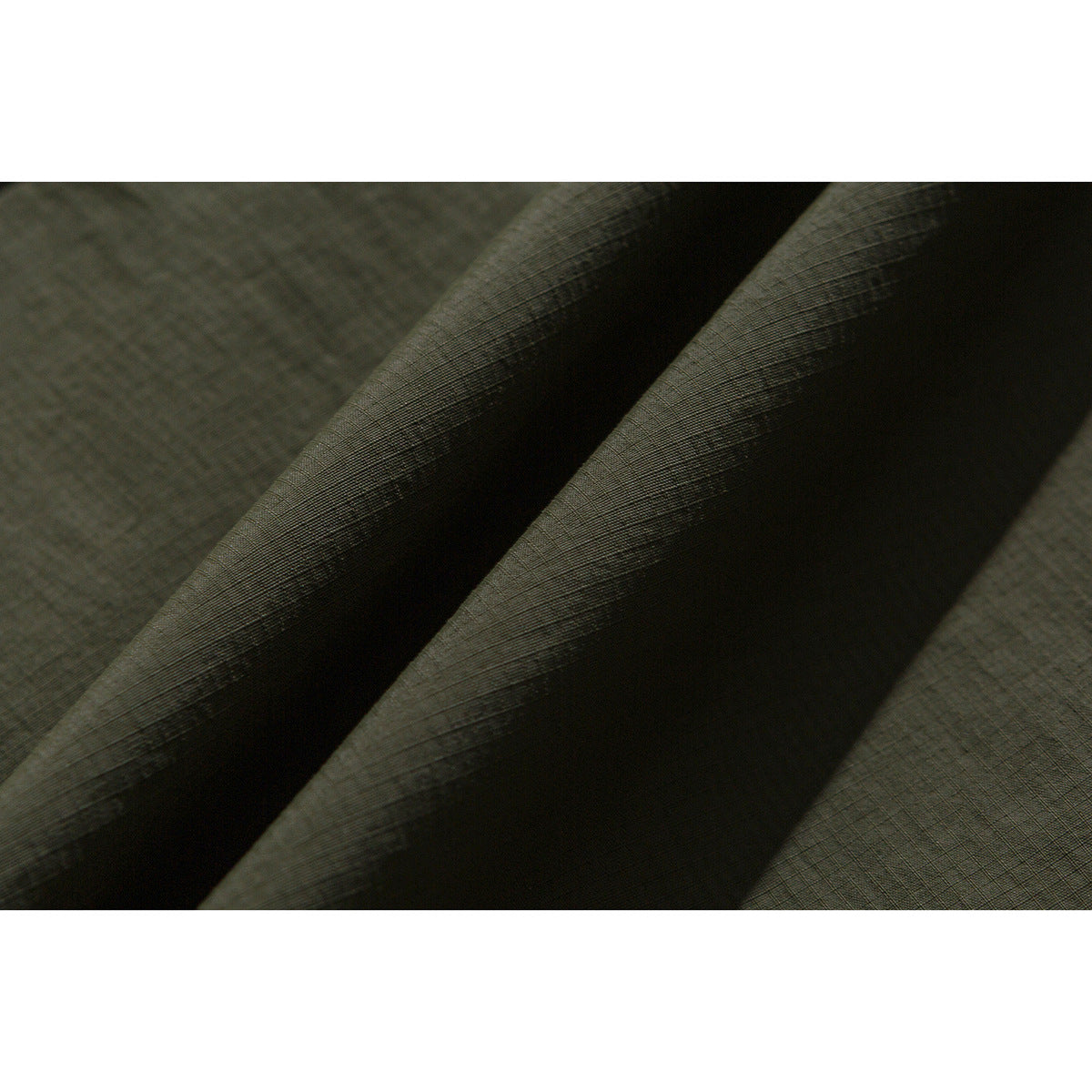 Close-up showing the fine grid texture and folds of dark olive jacket fabric.