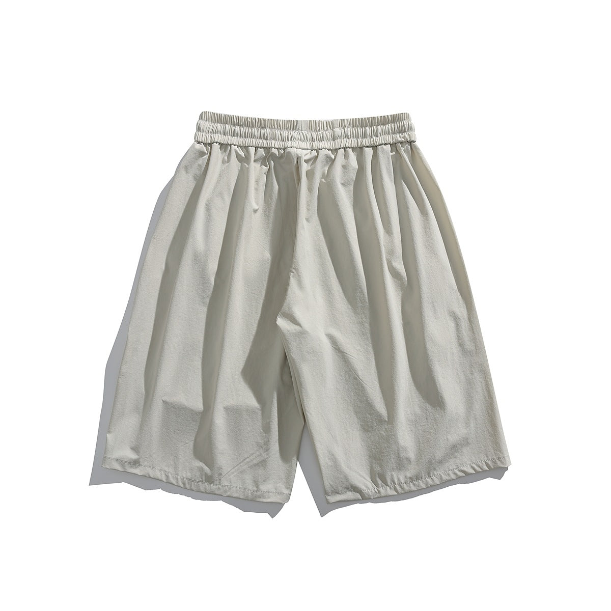 Front view of light ivory wide-leg shorts with a gathered elastic waistband and roomy legs, displayed flat on white.