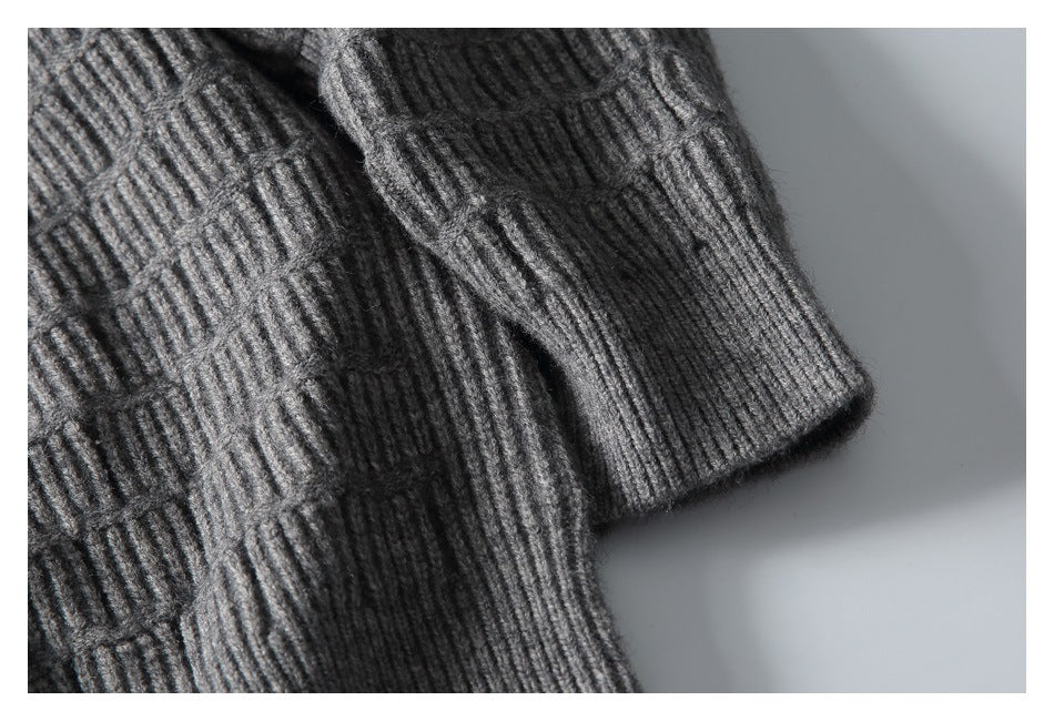 Close-up of the gray sweater's textured knit and ribbed sleeve cuff.