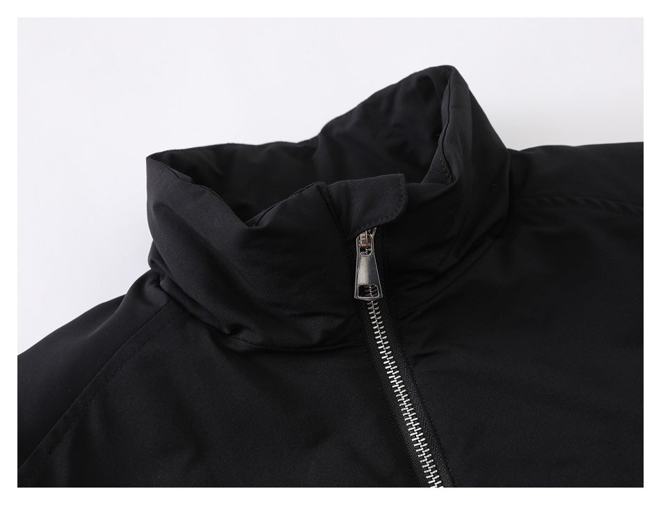 Close-up of the black jacket's high collar and silver front zipper with a snap-tab at the top.