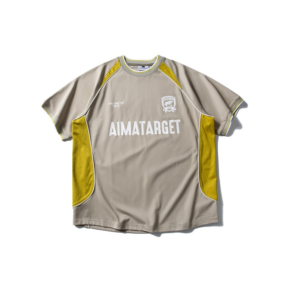 Front view of a taupe short-sleeve T-shirt with yellow panels, white piping, and white chest graphics.