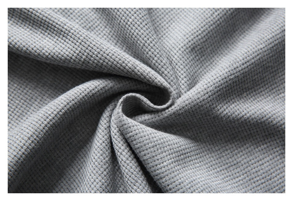 Close-up of gray fabric gathered to show its small textured weave.