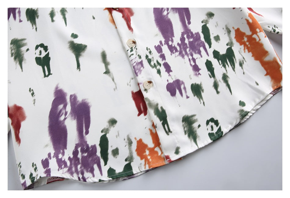 Close-up of the shirt's button placket and hem with a multicolor blurred-figure print.