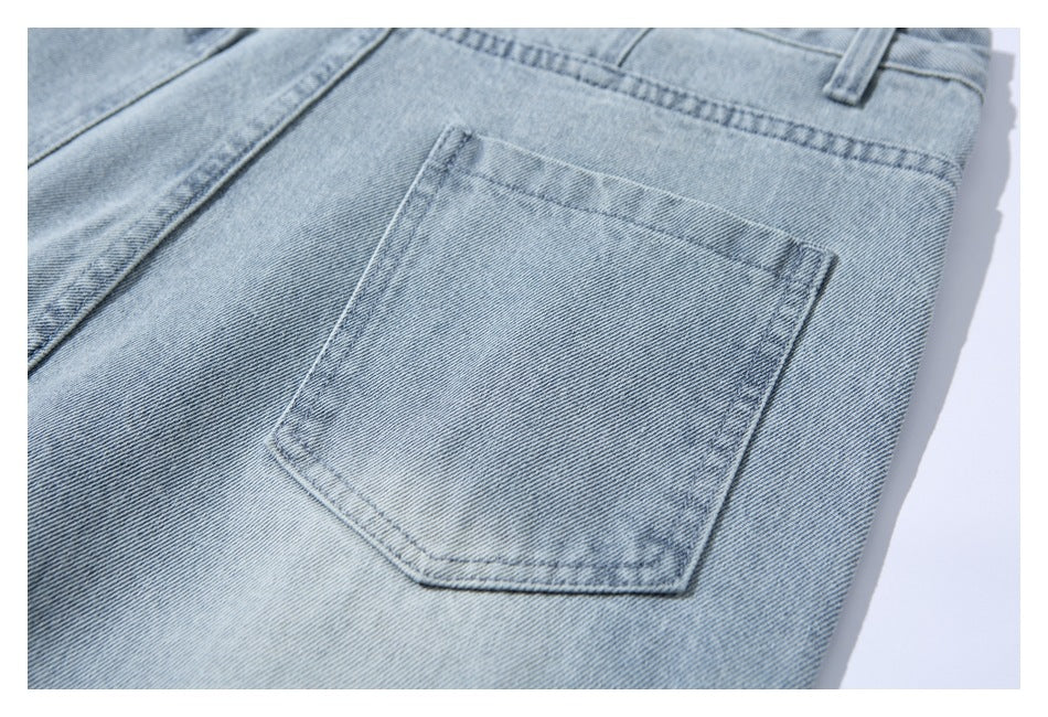 Close-up of a rectangular stitched back pocket on light-wash blue denim pants.