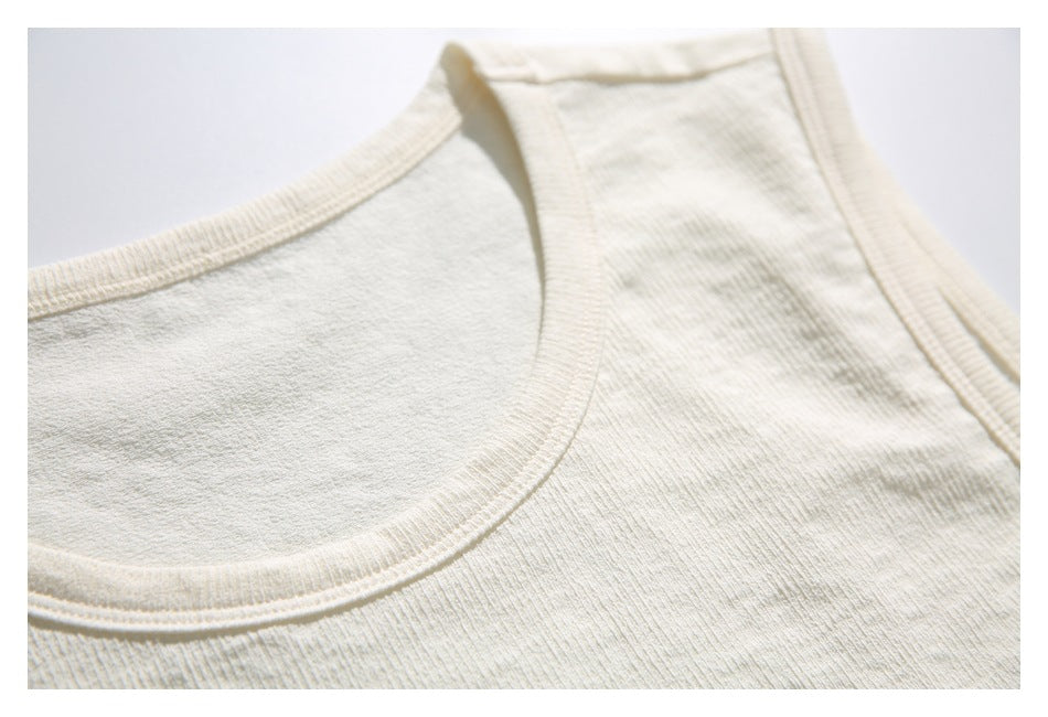Close-up of the ivory top's scoop neckline and shoulder straps, showing the stitched binding.