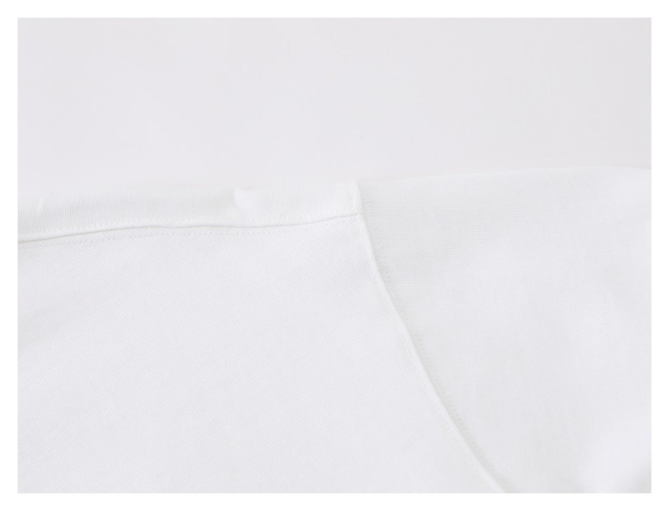 Close-up of white shirt fabric and shoulder seam stitching.