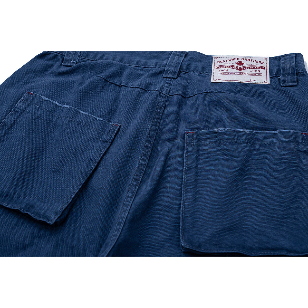 Close-up of dark blue trousers showing the back waistband, belt loops, two patch pockets, and sewn label.