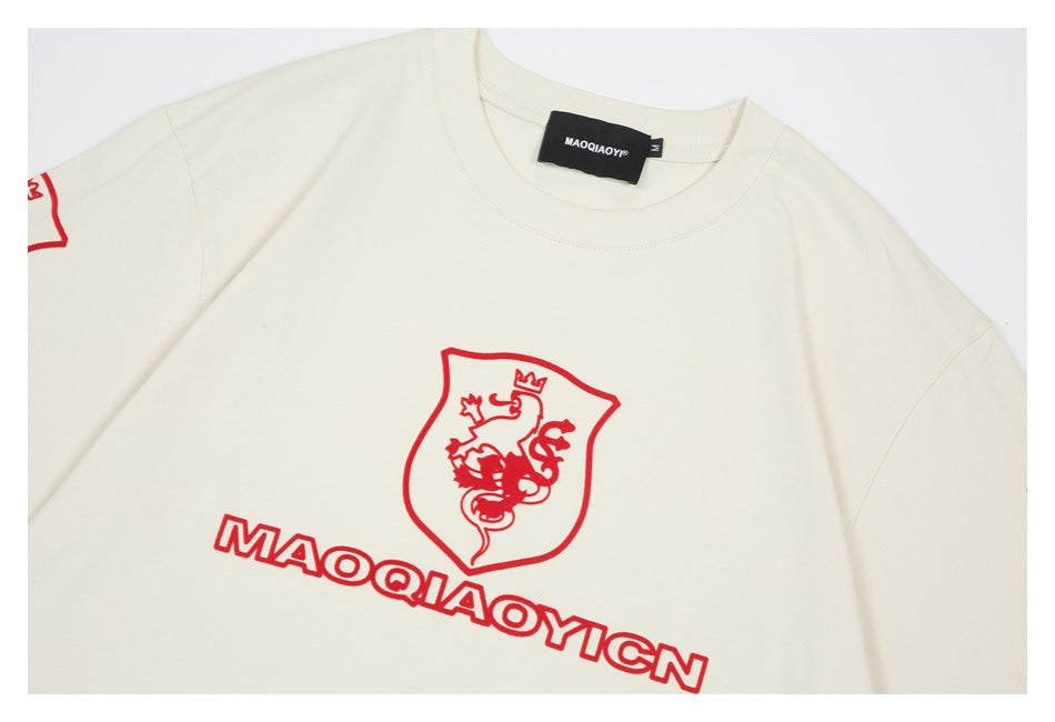 Close-up of an ivory sweatshirt front with a red crowned-lion crest and outlined lettering.