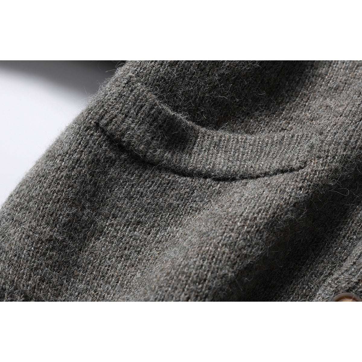 Close-up of the gray cardigan's knit texture and a folded seam.