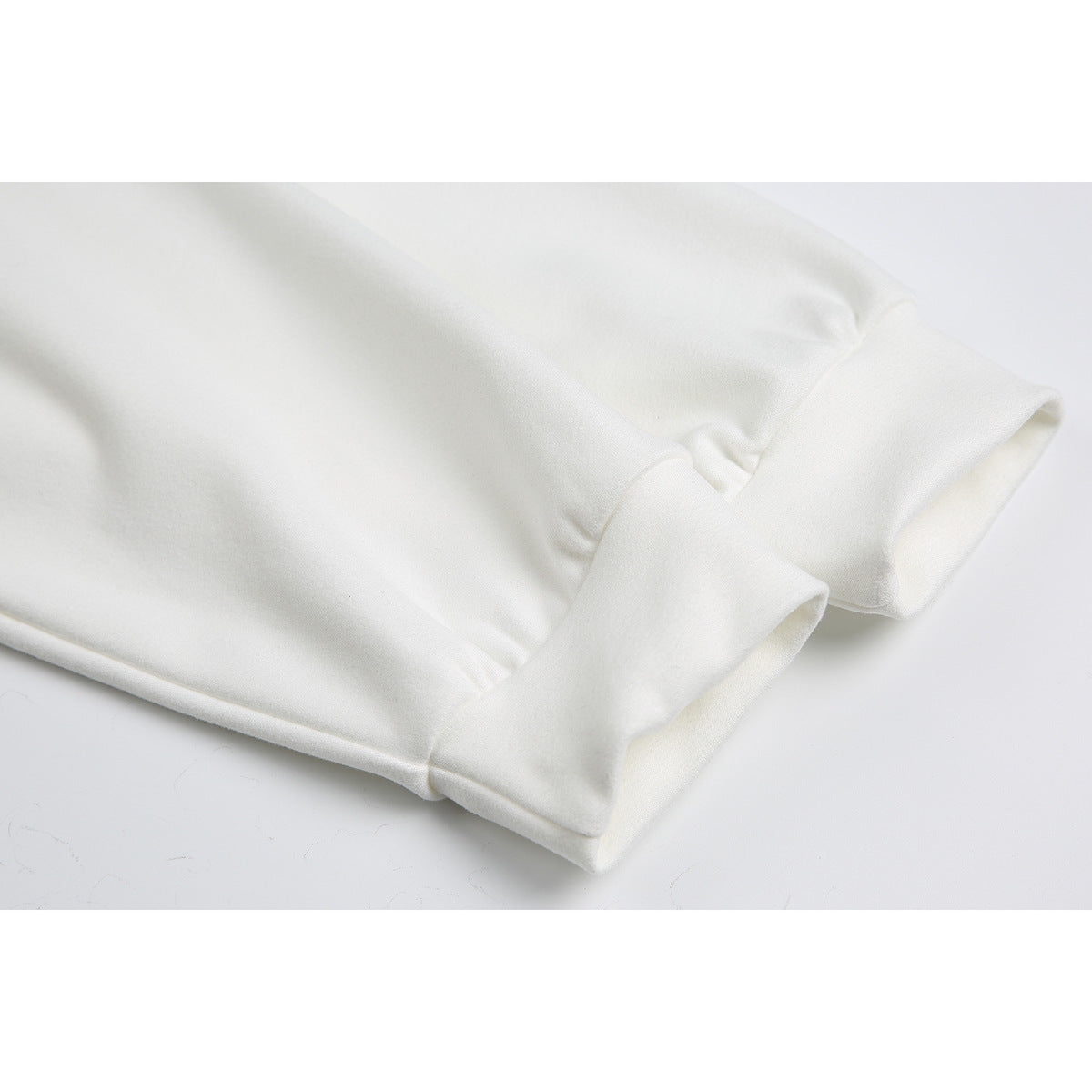Close-up of the white shirt's long sleeves and wide ribbed cuffs.