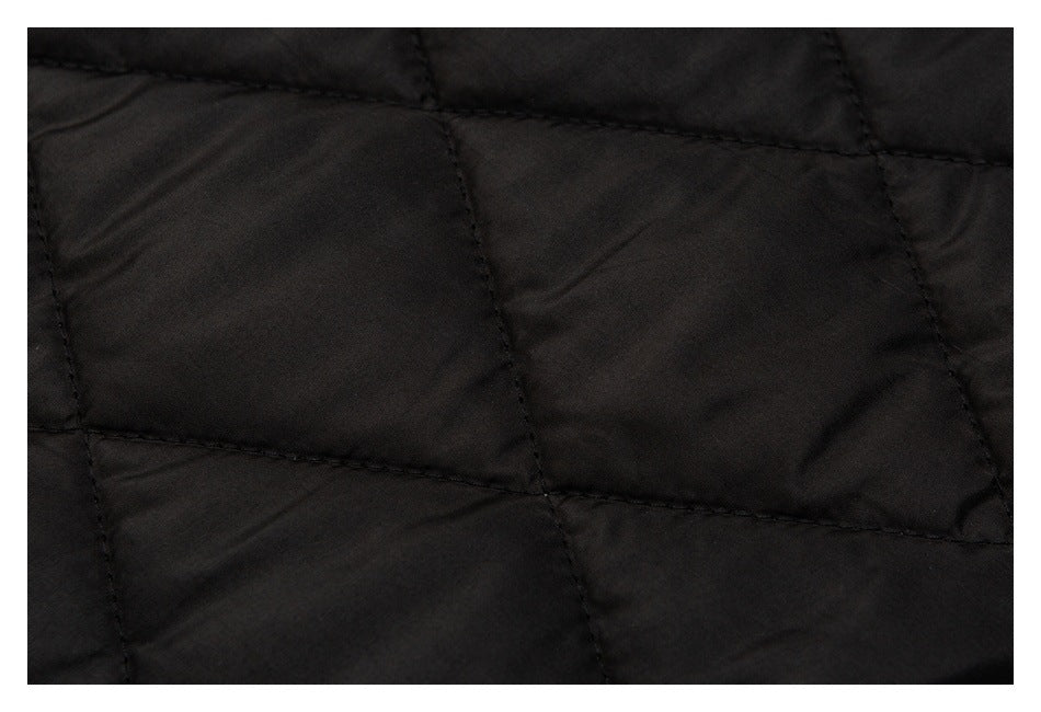 Close-up of black fabric with large stitched quilted panels.