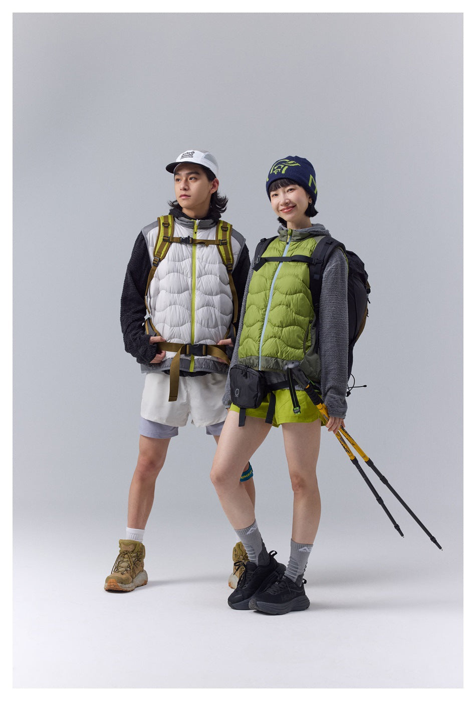 Two models wearing wave-quilted vests, one white and one lime green, with hiking gear.