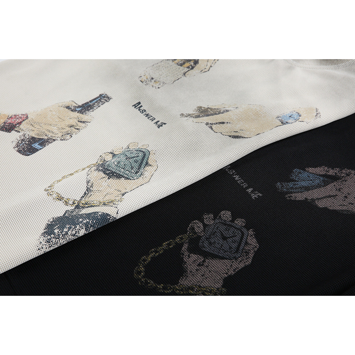 Close-up of cream and black tops with illustrated hand-and-object prints and the words “ANSWER ME.”