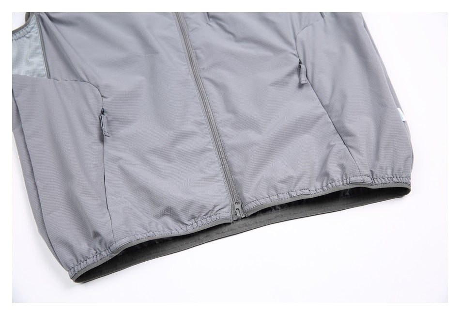 Close-up of the gray vest's front zipper, zip pockets, and elasticized lower hem.