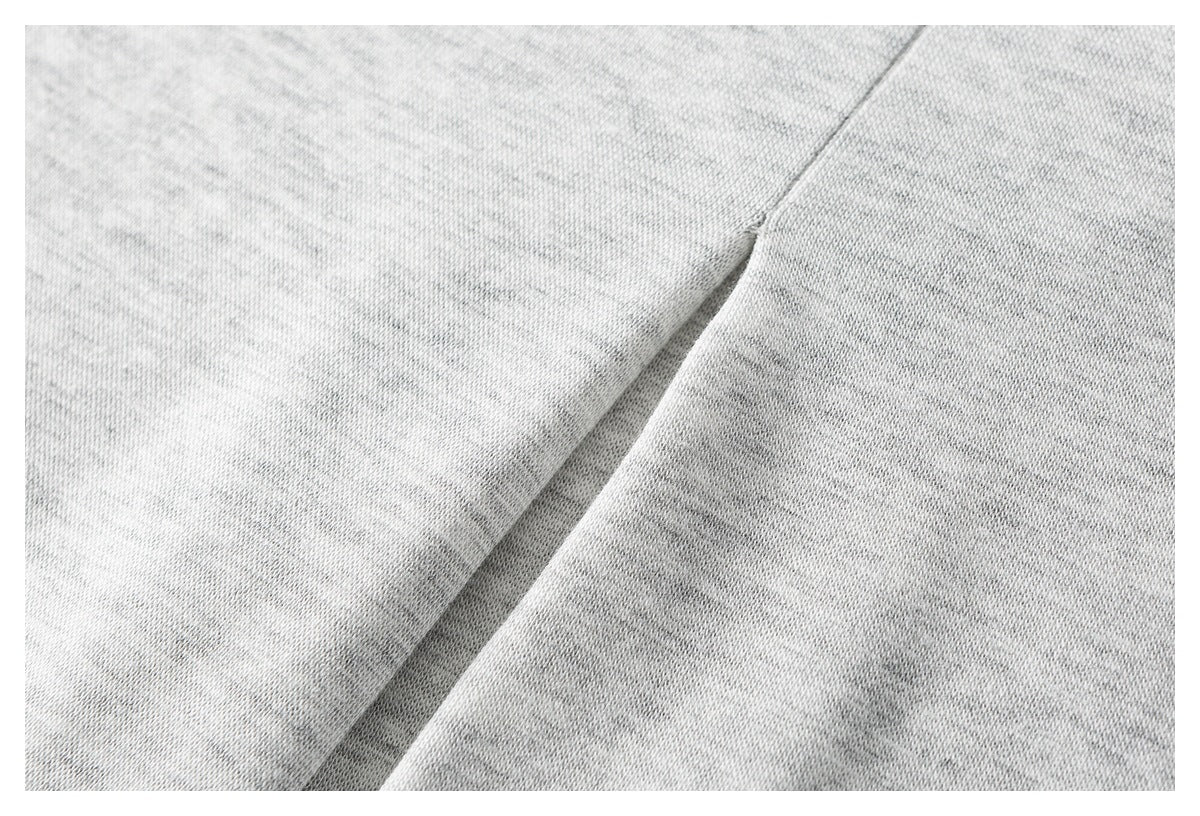 Close-up of a diagonal seam in light gray heathered fabric.