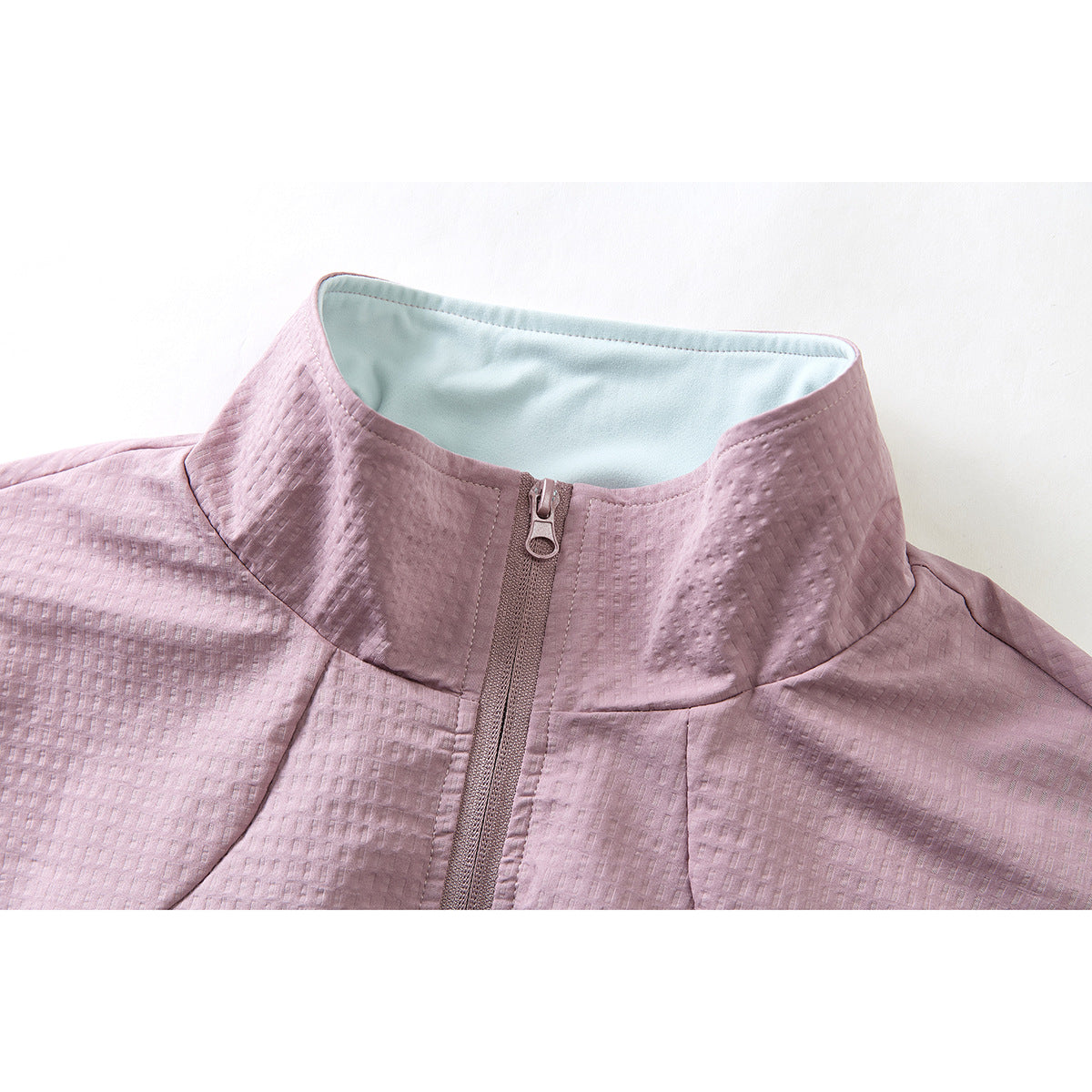 Close-up of a dusty mauve jacket's textured fabric, high stand collar, pale blue lining, and front zipper.