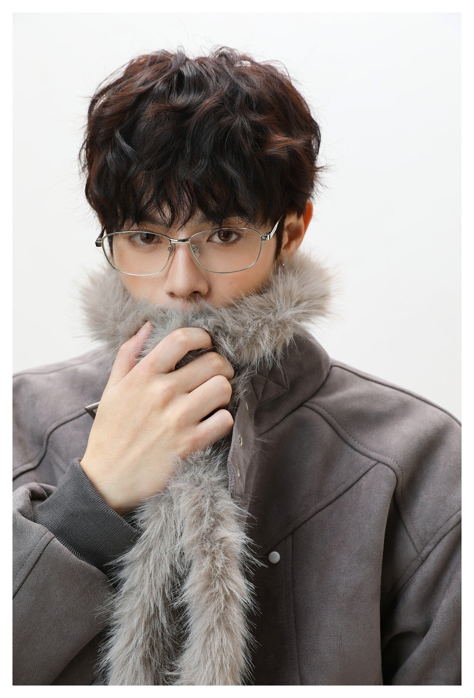 Close-up of a gray jacket's plush light gray fur collar and front trim, worn by a model.