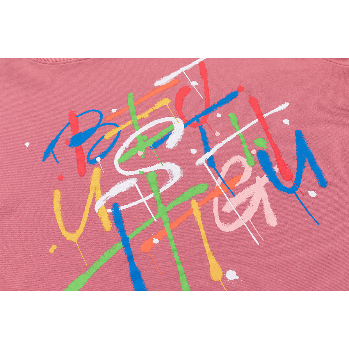 Close-up of colorful abstract lettering printed on dusty rose sweatshirt fabric.