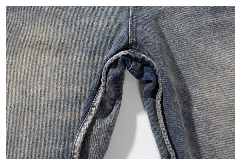 Close-up of the inner leg seam and crotch construction on washed gray-blue denim shorts.