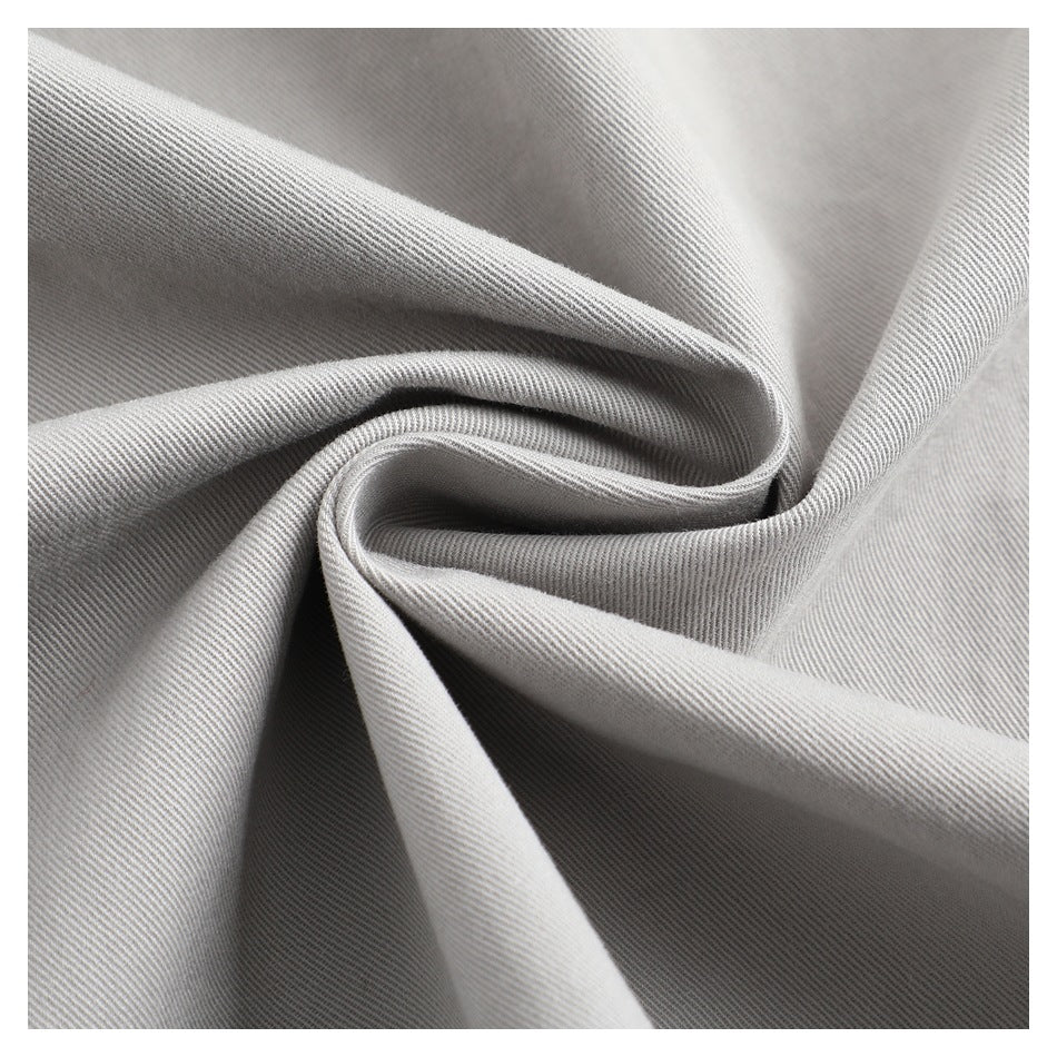Macro view of light gray twill fabric folded to show its diagonal weave.
