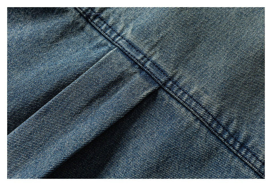Close-up of blue denim with a double-stitched seam and folded fabric.